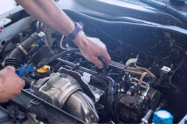 Mechanic working on a car engine with tools